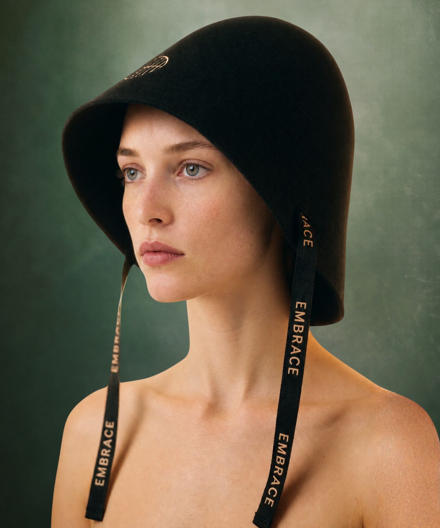 A woman wearing the black merino wool Embrace Sauna Hat in a studio editorial portrait